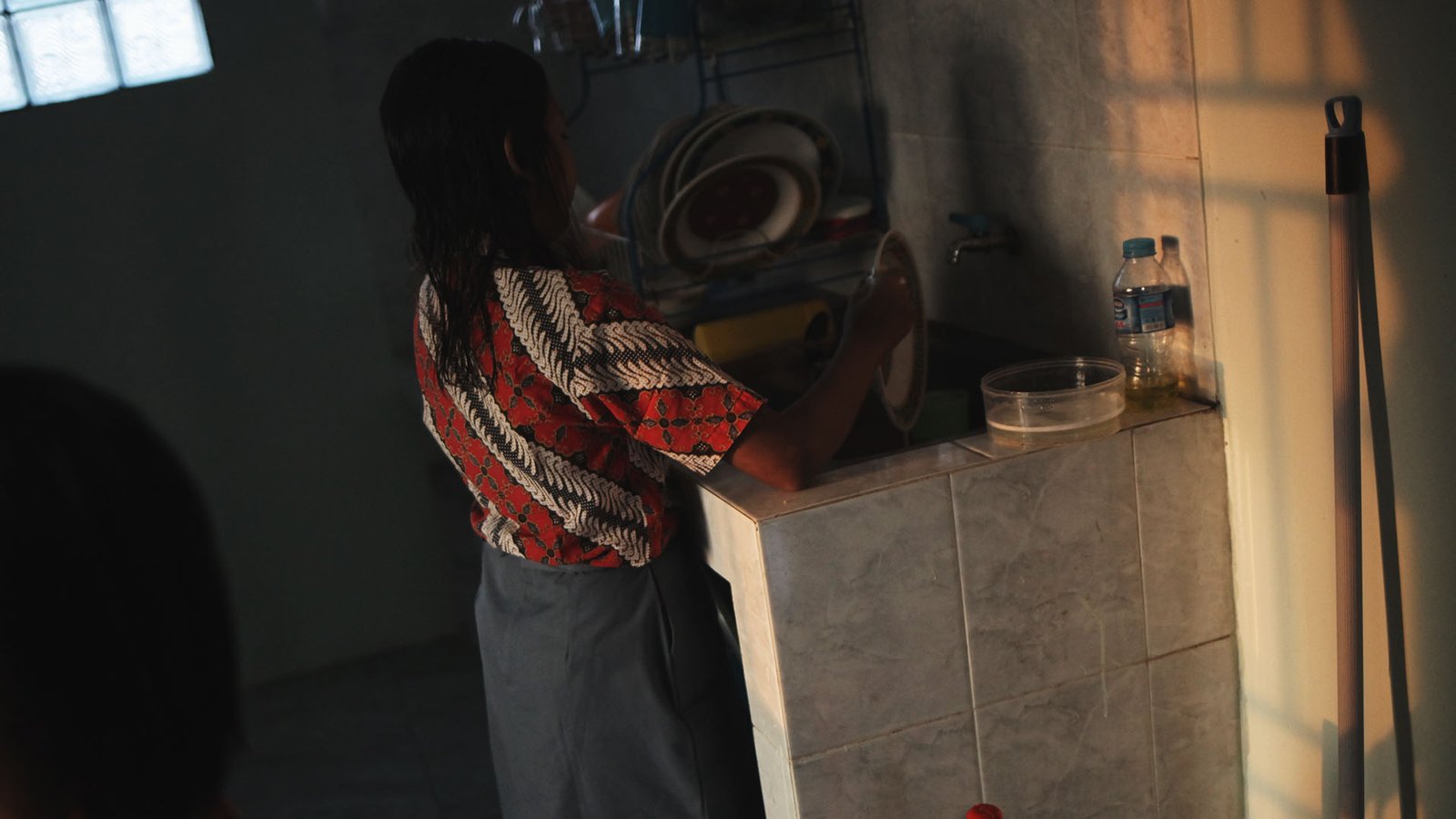 A girl washing doing her routine cleaning dishes